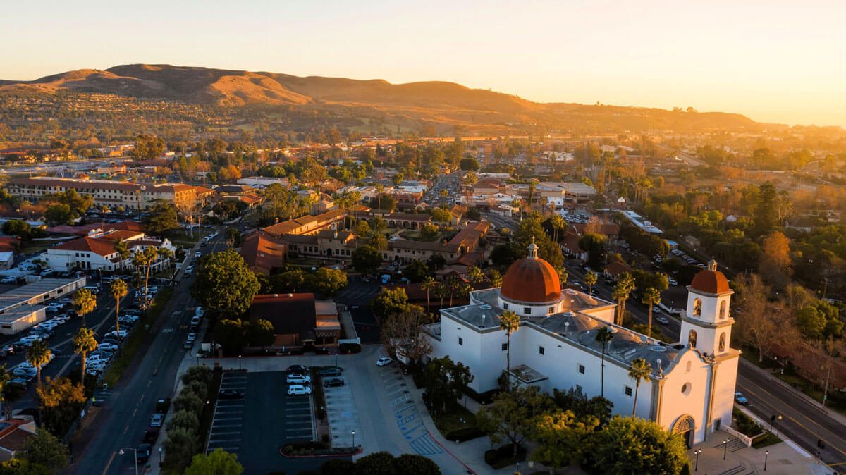 San Juan Capistrano at sunset from the air, the basilica dome and the hills behind the town